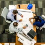 photo shot from above of people at a table studying blueprints