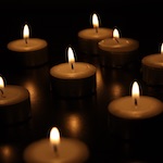 Photo by Hakan Erenler of lit candles in a dark room