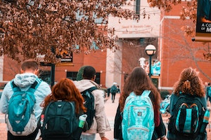 photo by Stanley Morales of students walking into college wearing backpacks