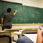 photo by Pixabay of teacher writing on chalk blackboard