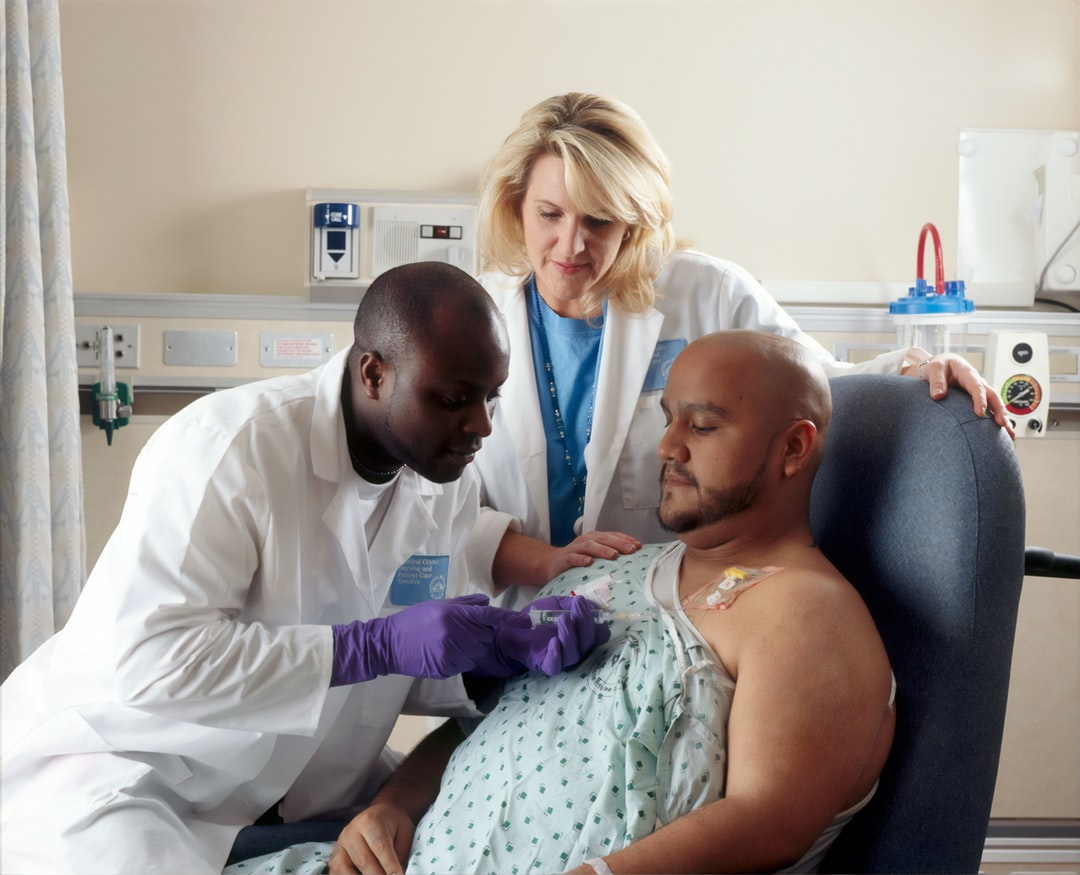hoto from the National Cancer Institute of a nurse administering chemotherapy to a patient while another nurse looks on. Source: Unsplash